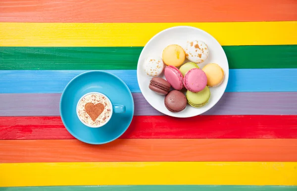 Taza de café con forma de corazón cerca de macarons — Foto de Stock