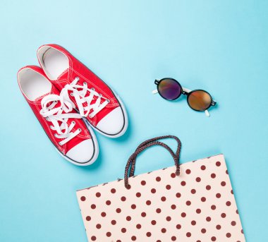 Red gumshoes with shpping bags and sunglasses  clipart