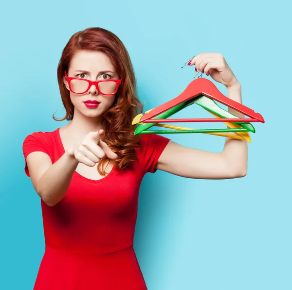 Verrast roodharige meisje met hangers — Stockfoto