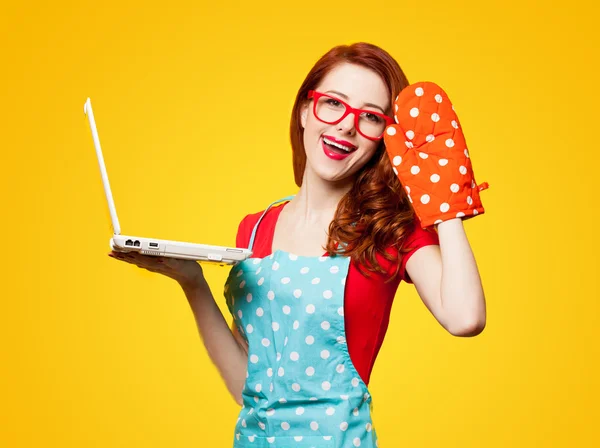 Junge Hausfrau mit Computer und Ofenhandschuhen — Stockfoto