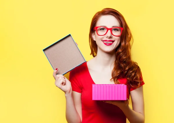 Niña en vestido rojo con gafas y caja de regalo — Foto de Stock