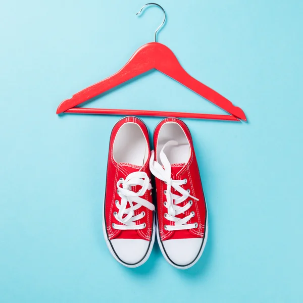 Red gumshoes with white shoelaces and hanger — Stock Photo, Image