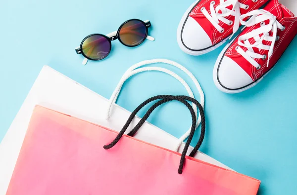 Red gumshoes with shpping bags and sunglasses — Stock Photo, Image