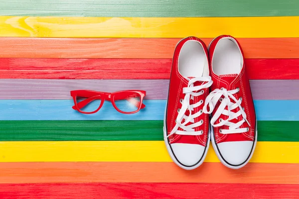 Gumshoes with white shoelaces and glasses — Stock Photo, Image