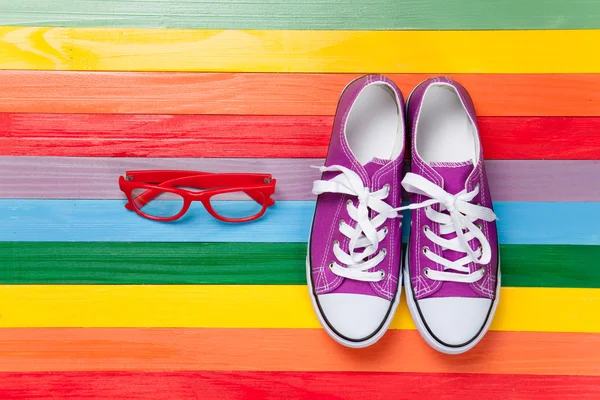 Gumshoes with white shoelaces and glasses — Stock Photo, Image