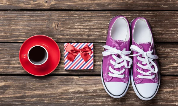 Gumshoes y caja de regalo con taza de café — Foto de Stock