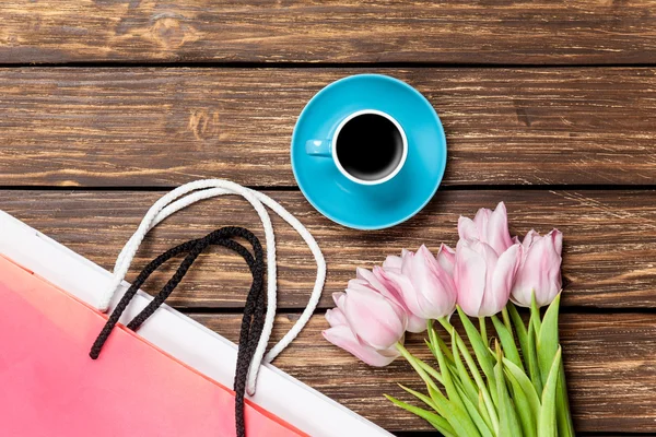 Bolsas con taza de café y tulipanes — Foto de Stock