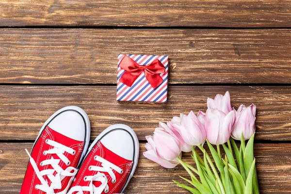 Gumshoes and gift box with tulips — Stock Photo, Image