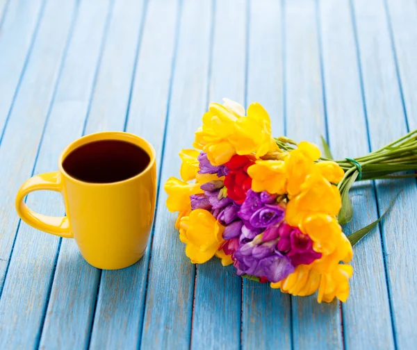 Cup of coffee and bouquet of flowers — Stock Photo, Image