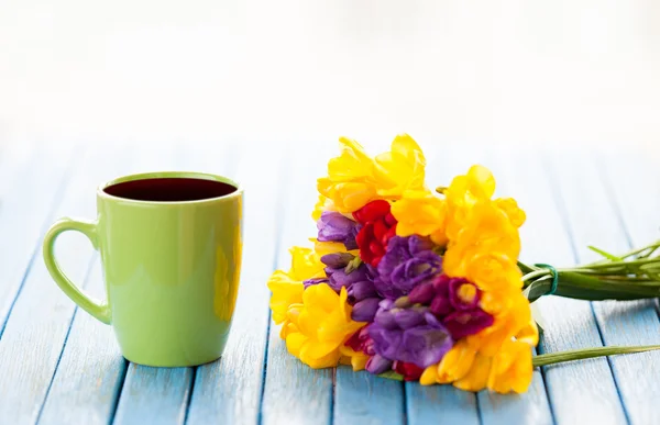 Cup of coffee and bouquet of flowers — Stock Photo, Image