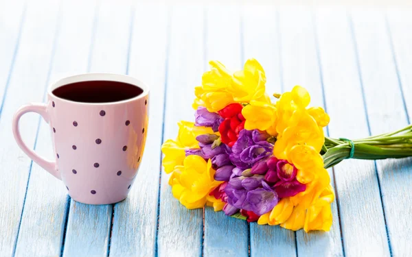 Cup of coffee and bouquet of flowers — Stock Photo, Image