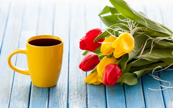 Kopje koffie en een boeket van tulpen — Stockfoto