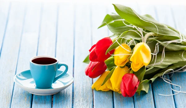 Cup of coffee and bouquet of tulips — Stock Photo, Image