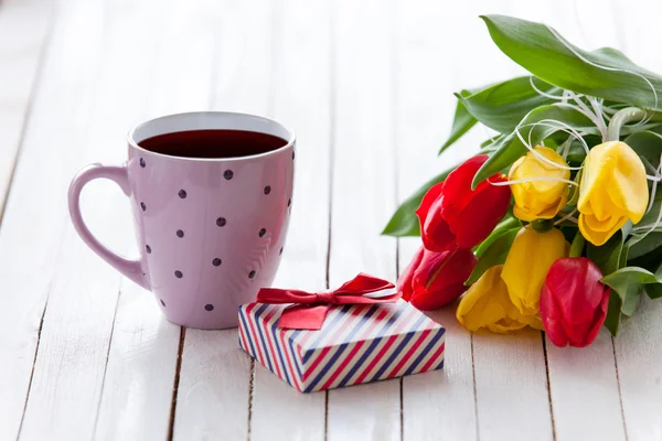 Cup en geschenk doos met boeket van tulpen — Stockfoto