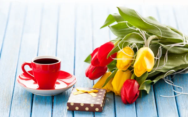 Cup en geschenk doos met boeket van tulpen — Stockfoto