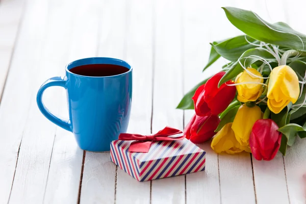 Cup en geschenk doos met boeket van tulpen — Stockfoto