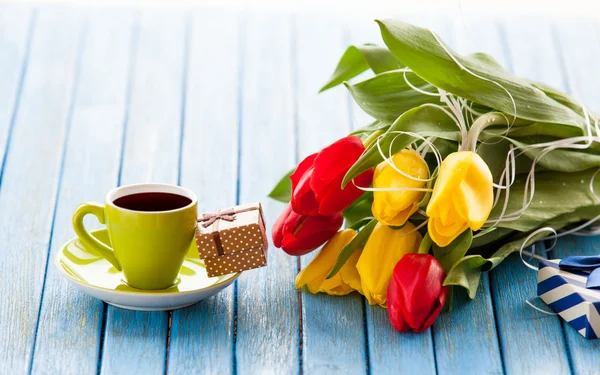 Cup en geschenk doos met boeket van tulpen — Stockfoto