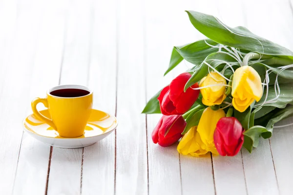 Xícara de café e buquê de tulipas — Fotografia de Stock