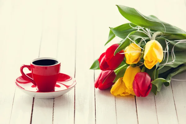 Cup of coffee and bouquet of tulips — Stock Photo, Image
