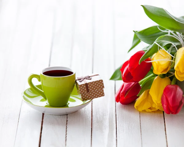 Cup and gift box with bouquet of tulips — Stock Photo, Image