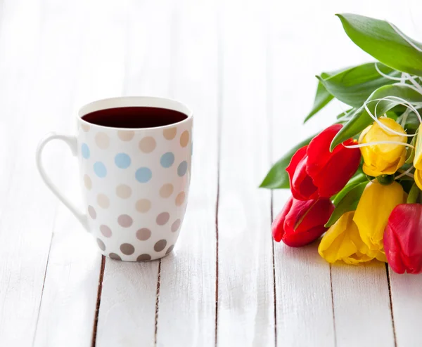 Kopje koffie en een boeket van tulpen — Stockfoto