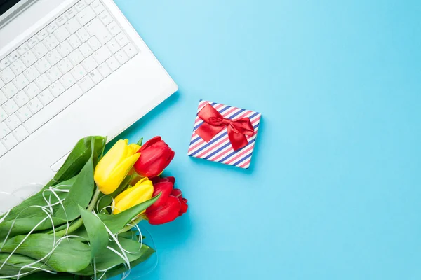 Computador branco e buquê de tulipas com presente — Fotografia de Stock