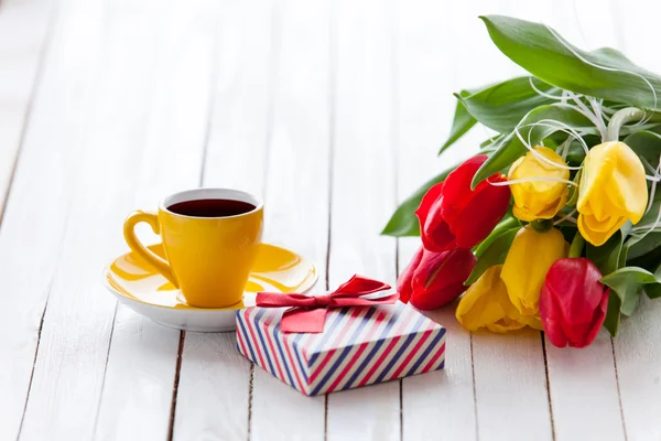 Cup en geschenk doos met boeket van tulpen — Stockfoto