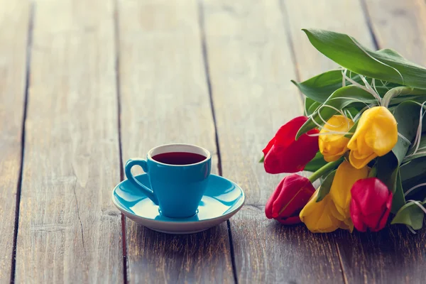 Xícara de café e buquê de tulipas — Fotografia de Stock