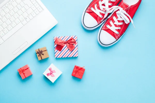 Witte computer en gumshoes met geschenken — Stockfoto