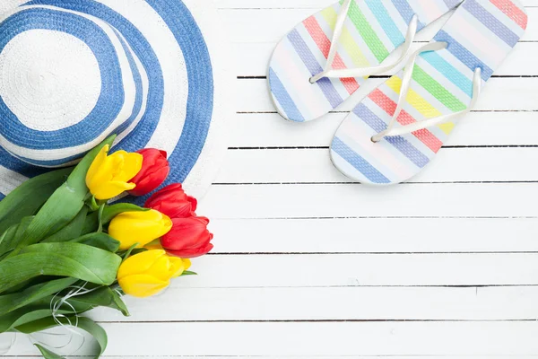 Ramo de tulipanes y chanclas con sombrero azul — Foto de Stock