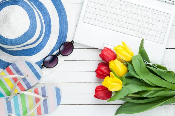 Computador branco e chinelos sapatos com tulipas — Fotografia de Stock