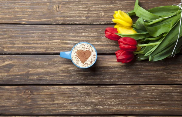 Cappuccino a forma di cuore e bouquet di tulipani — Foto Stock