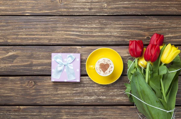 Cappuccino with heart shape and bouquet of tulips — Stock Photo, Image