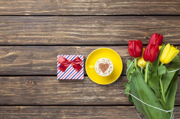Cappuccino s tvaru srdce a kytice tulipánů — Stock fotografie