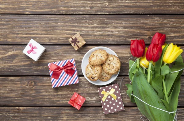 Cookies e caixas de presente perto de tulipas — Fotografia de Stock