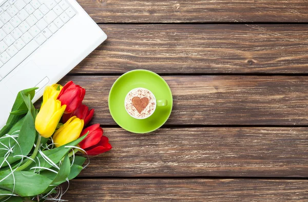 Šálek cappuccino s tvaru srdce a počítač — Stock fotografie