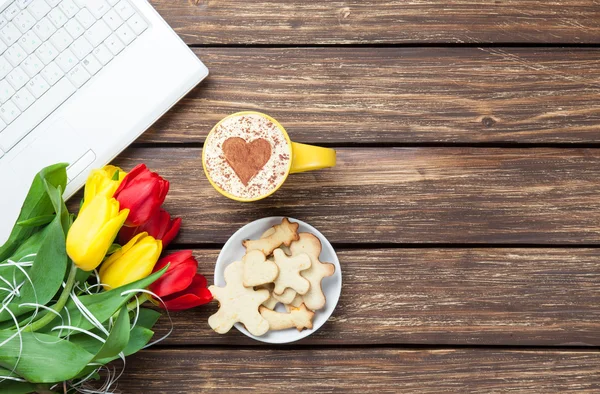 Šálek cappuccino s tvaru srdce a počítač — Stock fotografie