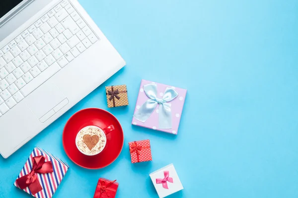 Ordenador con bxes regalo y cappuccino — Foto de Stock