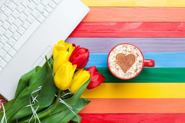 Šálek cappuccino s tvaru srdce a počítač — Stock fotografie