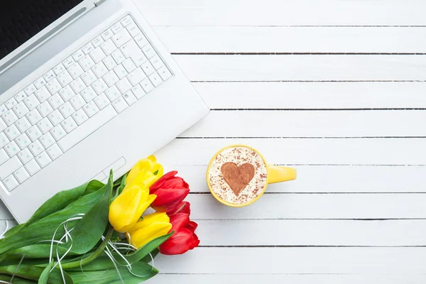 Xícara de cappuccino com forma de coração e computador — Fotografia de Stock