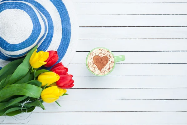 Tazza di cappuccino a forma di cuore e bouquet di tulipani — Foto Stock