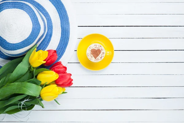 Чашка капучино в форме сердца и букет тюльпанов — стоковое фото