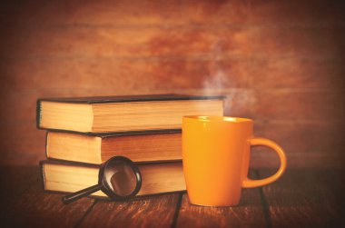 Fincan kahve ve kitap büyüteç ile 