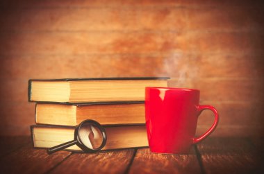 Fincan kahve ve kitap büyüteç ile 