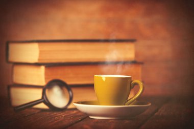 Fincan kahve ve kitap büyüteç ile 
