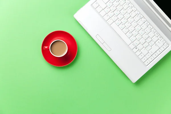 Rode kopje koffie en witte laptop — Stockfoto