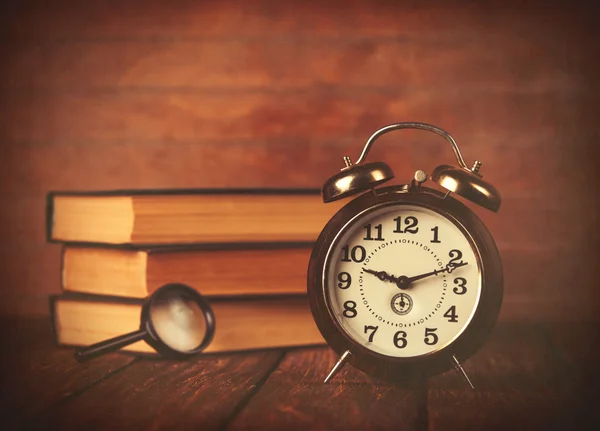 Büyüteç ve retro çalar saat ile kitapları — Stok fotoğraf