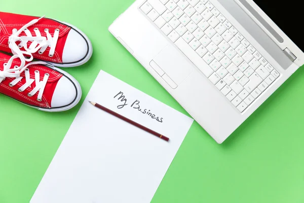 Обувь и бумага рядом с ноутбуком — стоковое фото