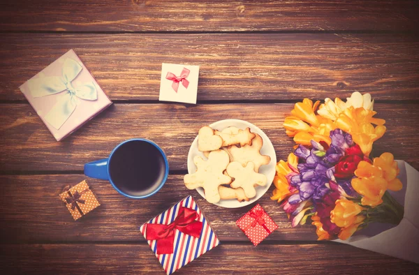 Tasse Kaffee und Geschenk mit Blumen — Stockfoto