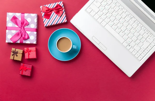 Tazza di caffè e regalo vicino al computer — Foto Stock